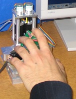 Figure 1c: Picture of hand holding the device with the index finger on the tactile display.